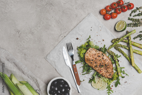 top view of delicious healthy baked meat with vegetables on grey