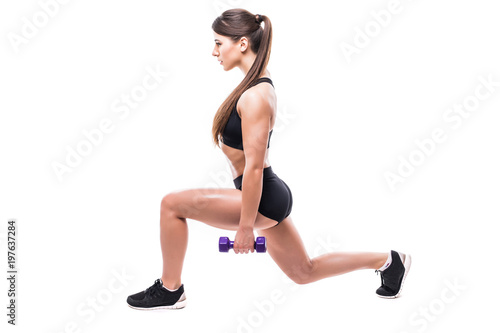 Beautiful young woman doing lunge exercise with red dumbbells in fitness gym isolated over white background
