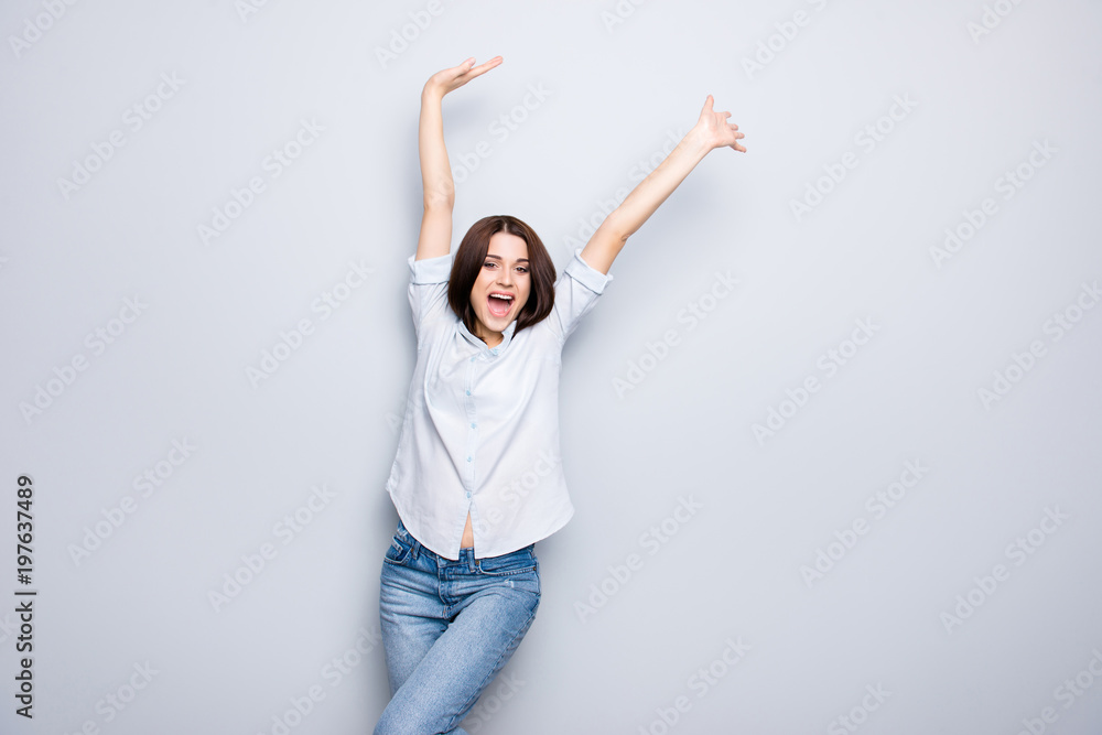 Portrait of charming, crazy, pretty, nice, happy, brunette, caucasian, modern girl with arms up and open mouth, yelling over grey background Portrait of charming, crazy, pretty, nice, happy, brunette, caucasian, modern girl with arms up and open mouth, yelling over grey background