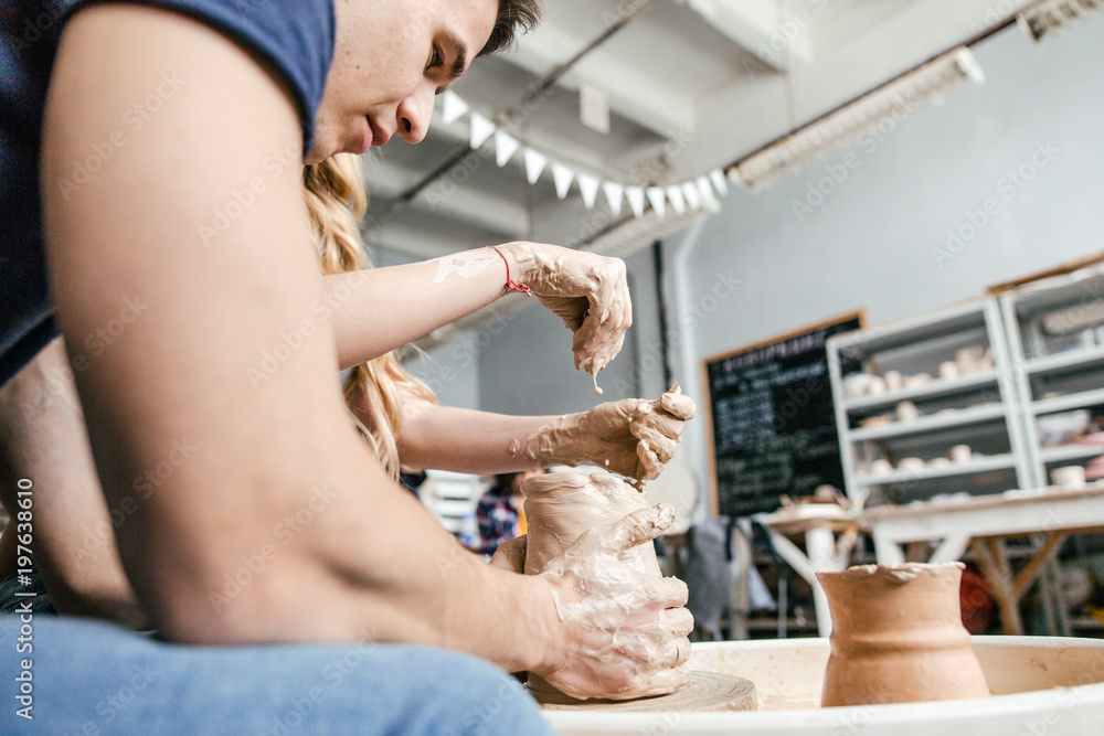 Obraz premium Family young couple make a pot using a pottery wheel in the Studio