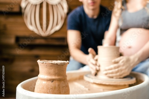 Family young couple make a pot using a pottery wheel in the Studio