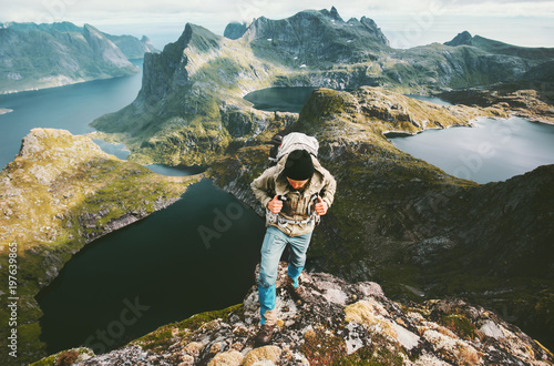 Traveler man exploring mountains in Norway with backpack Traveling lifestyle adventure outdoor concept hiking active summer vacations