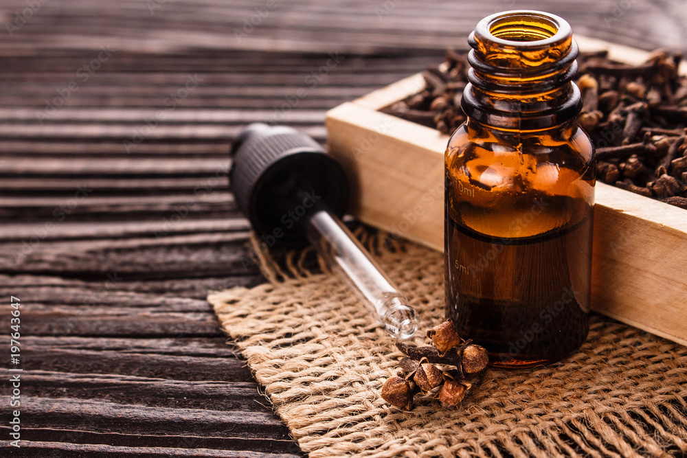 essential oil of cloves on a wooden rustic background essential oil of cloves on a wooden rustic background