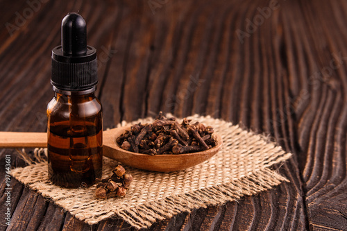 essential oil of cloves on a wooden rustic background