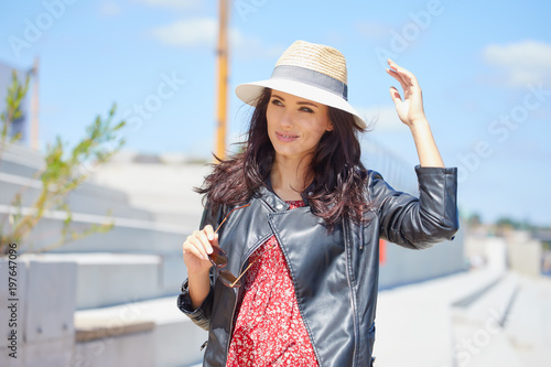 Portrait of happy smiling woman standing on the square on sunny summer or spring day outside, cute smiling woman looking at you, attractive young girl enjoying summer