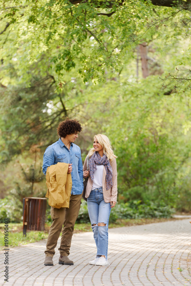 Young cheerful couple walking in the park Young cheerful couple walking in the park