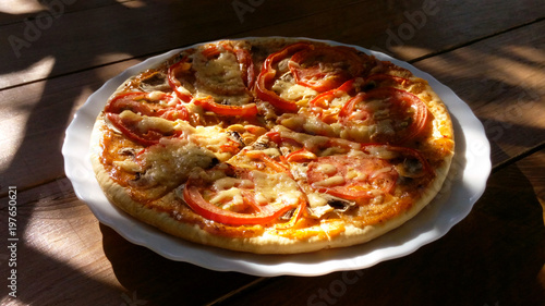 Pizza appetizing delicious juicy vegetarian in the sun in a summer cafe