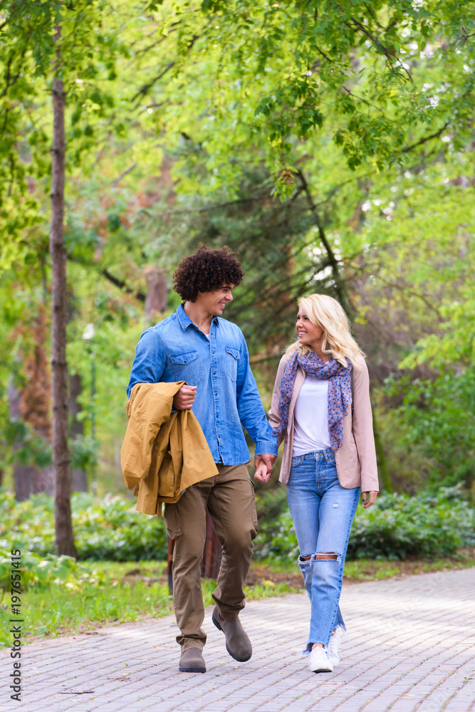 Young cheerful couple walking in the park Young cheerful couple walking in the park