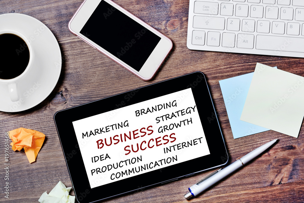 Business Success words on tablet device on a wooden table Business Success words on tablet device on a wooden table