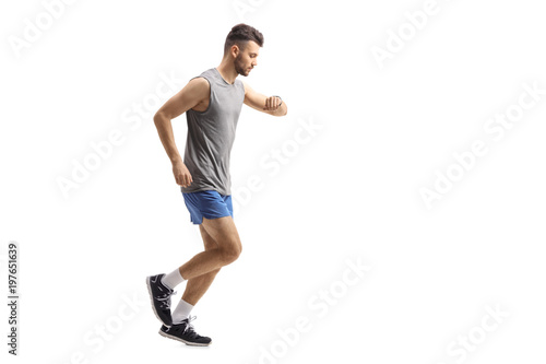 Athletic guy running and looking at his watch