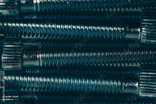 Background from automotive bolts in cyan tone close up.