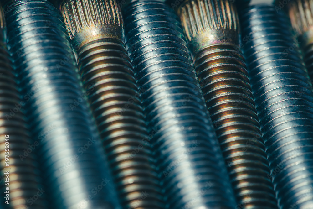 Background from automotive bolts in blue and yellow tones close up. Background from automotive bolts in blue and yellow tones close up.