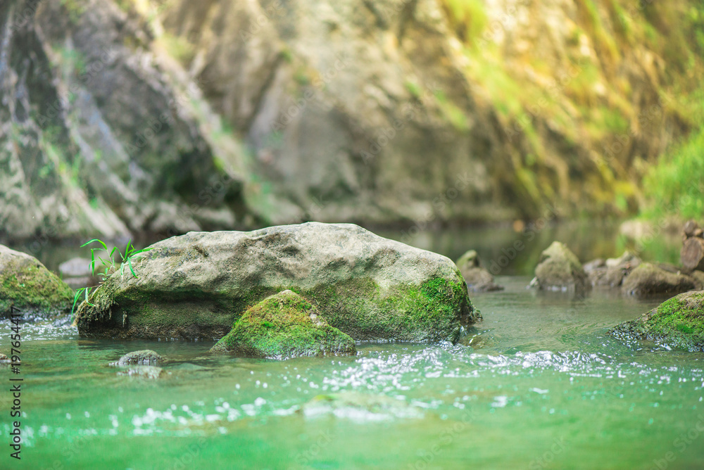  Small mountain waterfall on the rocks covered with moss deep in the forest. Cliffs in Cheile Turzii, Romania. Autumn is coming. Beautiful, calming nature background.
