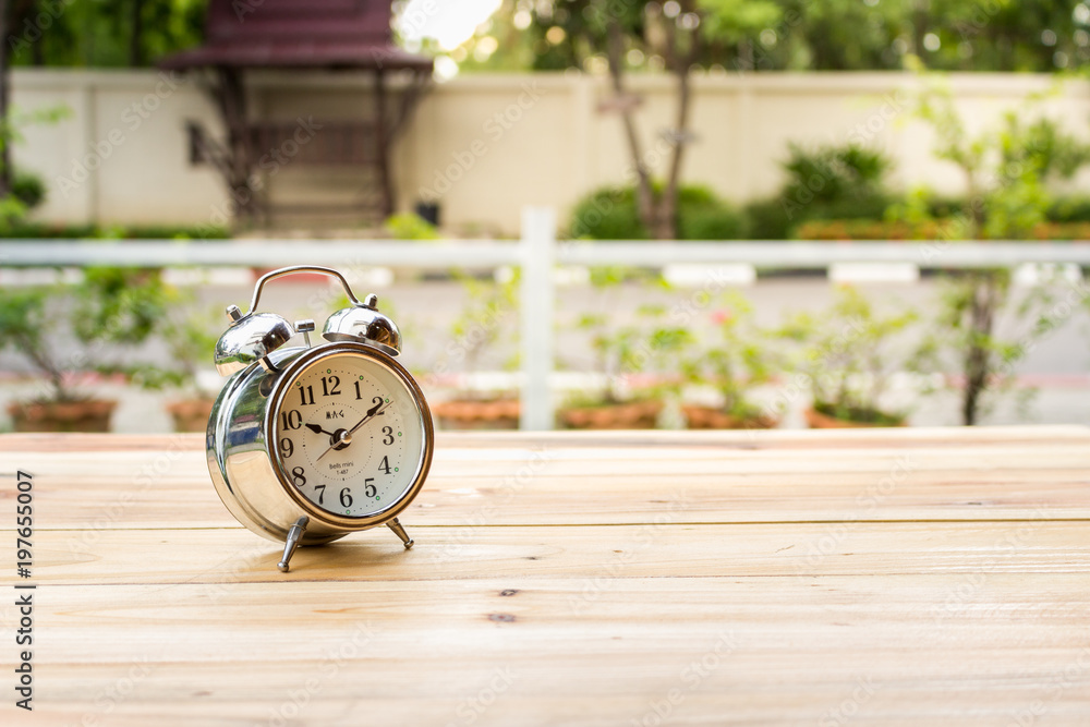 The clock is placed on a wooden table in the evening. The clock is placed on a wooden table in the evening.