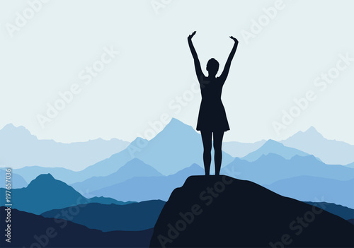 Young girl standing on rock and enjoying success in mountain landscape