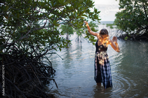 Fototapeta Naklejka Na Ścianę i Meble -  A young beautiful woman walks in a mangrove trees. Inside a mangrove forest Thailand