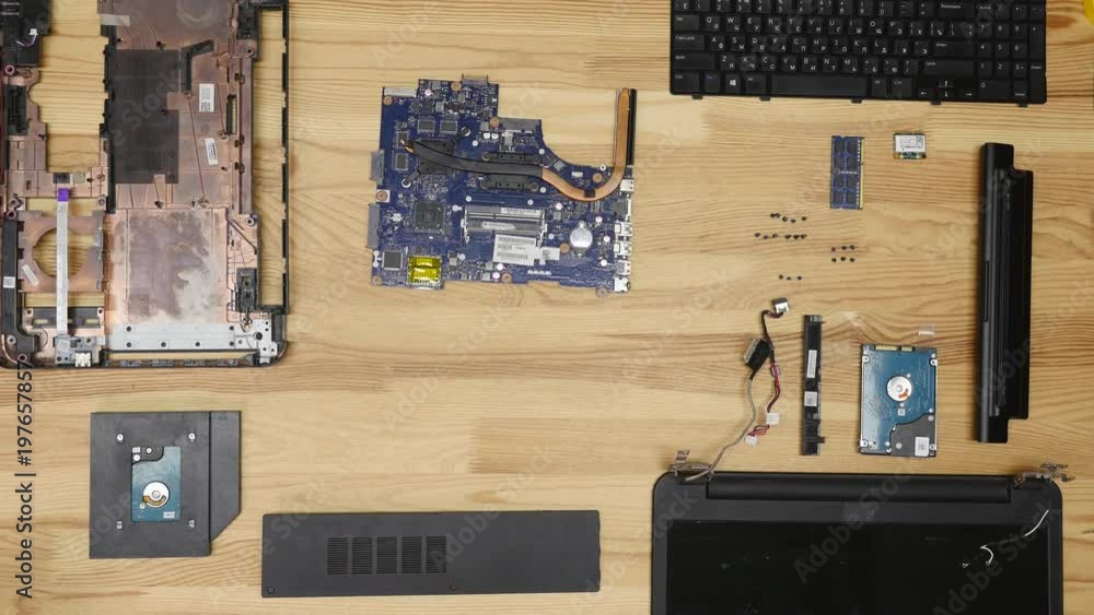 Labtop Assembly A man Assembling a laptop with a screwdriver. Wooden table top view ...