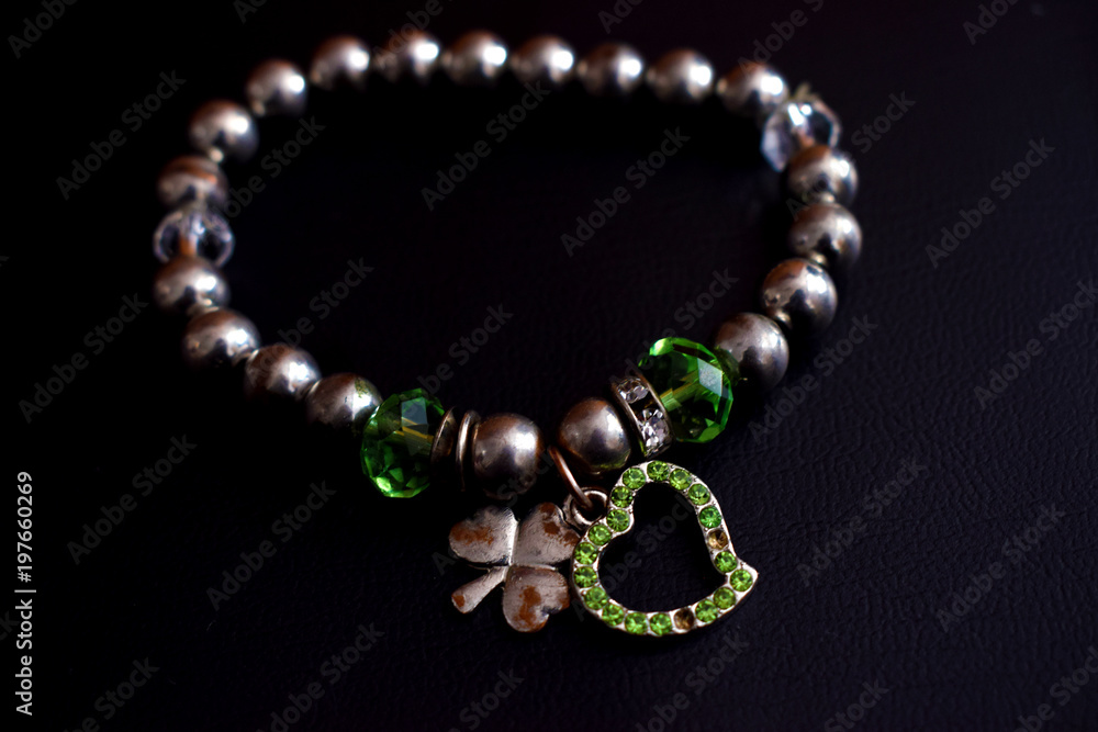Obraz premium Collar de perlas con colgante de corazones verde.