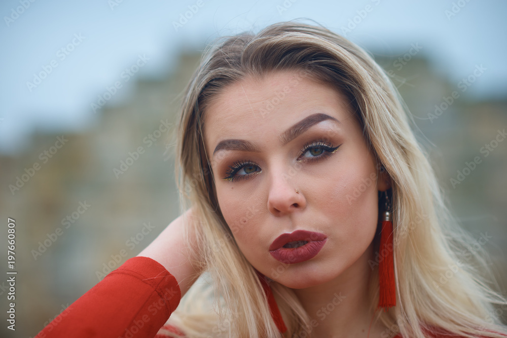 Fototapeta premium Young hot sexy woman in a short red dress outdoors
