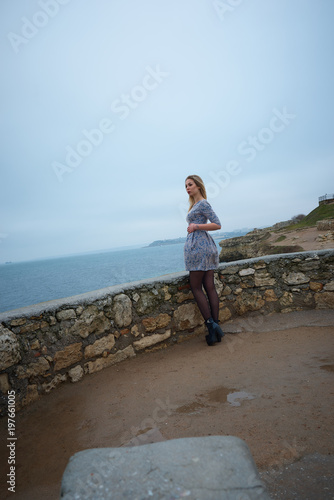 Young hot sexy woman in a short  dress walking near the sea © Sergey