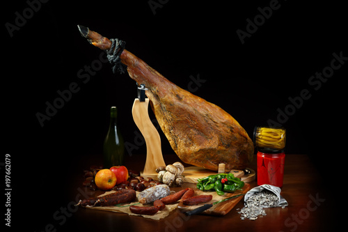 Hamon is forty-eight weeks old on the table. Still life with a Spanish jamon and traditional food.Food art in a low key. A selection of gastronomic products of Spain
