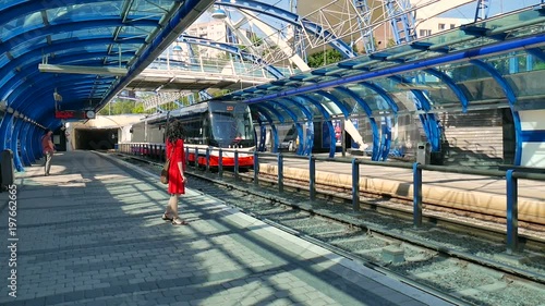 Czech Republic, Prague. May 29, 2017. Cute girl on the platform is auditing the arrival of the train. Railway station, public transport stop, modern architecture, tram, metro, train and transport