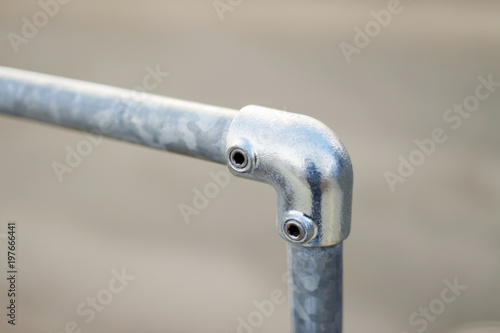 railing made of metal stainless steel pipes. Street. Fastening area with a bolt