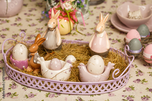 Easter decorative composition on a vintage background. Spring. A flowerpot with muscari flowers, a porcelain rabbits, eggs in the hay.