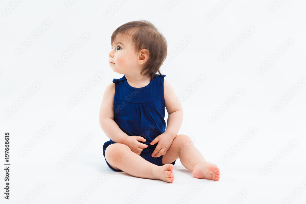 Cute funny small smiling girl sitting in studio posing on white background Cute funny small smiling girl sitting in studio posing on white background