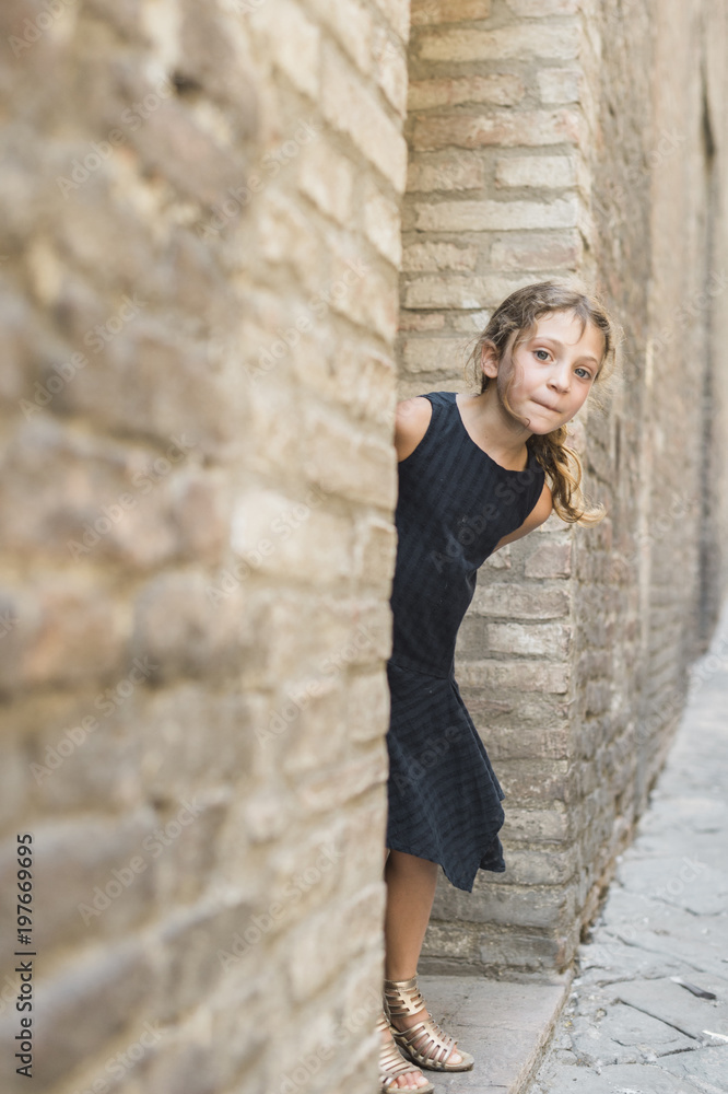 Portrait of girl peeking out from behind the wall Portrait of girl peeking out from behind the wall