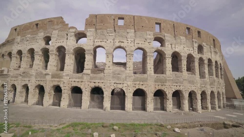 Wide angle view of the Colosseum exterior face as the camera tracks around the ancient amphitheater