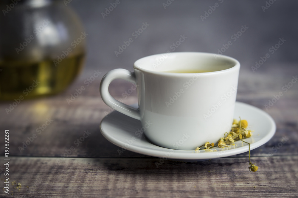 Close up of chamomile tea with flowers on table Close up of chamomile tea with flowers on table