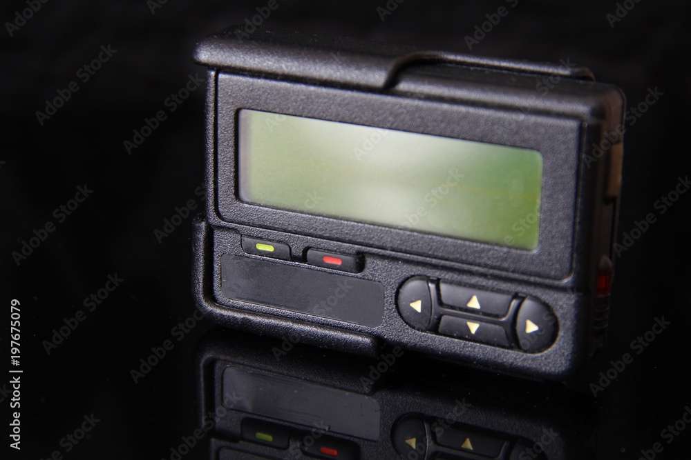 Old black pager or beeper isolated on black background. Vintage gadget for communication device Old black pager or beeper isolated on black background. Vintage gadget for communication device