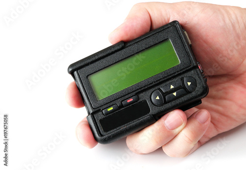 Old black pager in hand isolated on white background