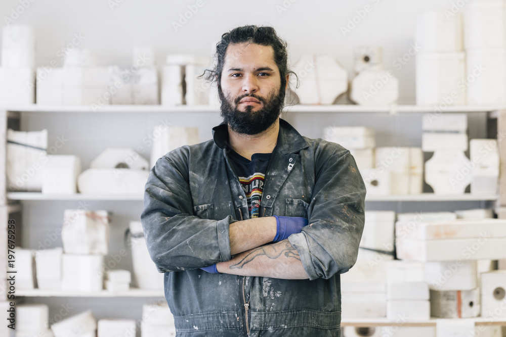 Portrait of craftsman with arms crossed standing at workshop Portrait of craftsman with arms crossed standing at workshop