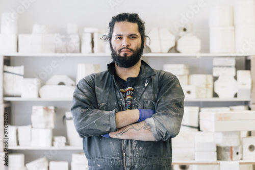 Portrait of craftsman with arms crossed standing at workshop photo