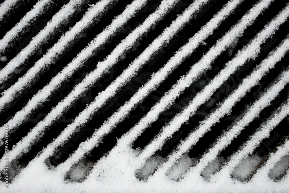 texture: sewer drain grate for water drainage in city streets, metal grid, iron manhole cover, covered with snow during a storm, blizzard, winter, mountain, Italy texture: sewer drain grate for water drainage in city streets, metal grid, iron manhole cover, covered with snow during a storm, blizzard, winter, mountain, Italy