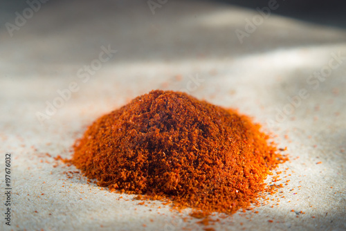 Spices are red, a pile of red pepper, paprika on coarse paper. Macro