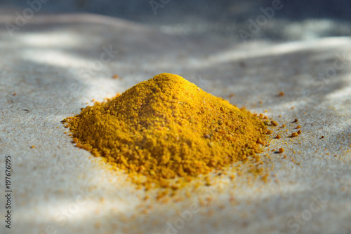 Spices - yellow, turmeric heap on coarse paper. Macro
