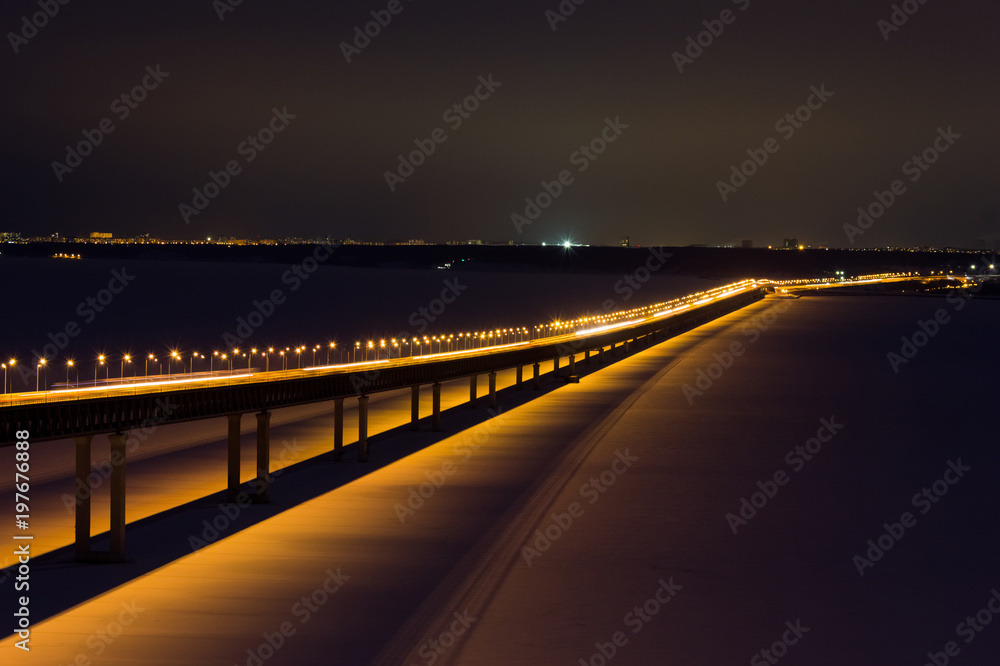 Fototapeta premium Long bridge in night with cars light in modern city. Bridge on the Volga River