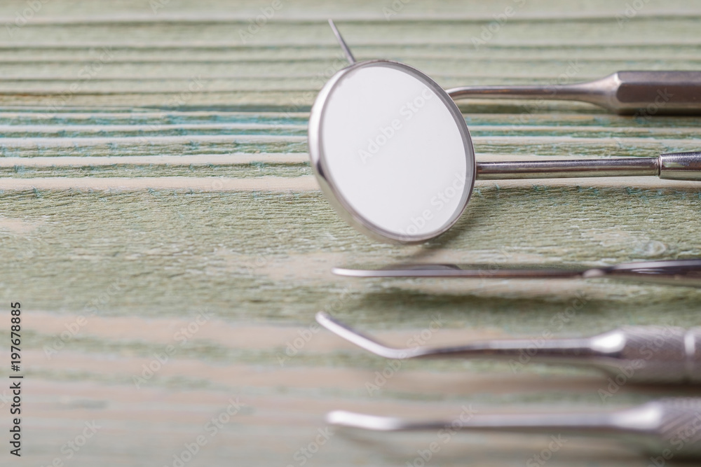 Dental tools, mirror close-up, on a wooden background Dental tools, mirror close-up, on a wooden background