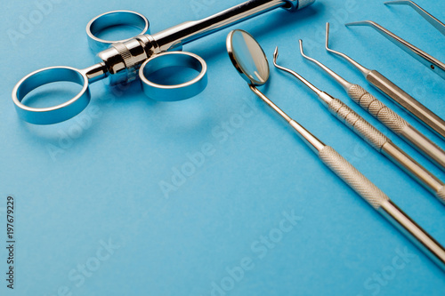 Syringe for injection, dental metal instruments on a blue background