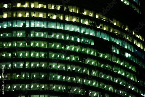 window of the night empty multi-storey skycraper building of glass and steel office lighting and with no people within