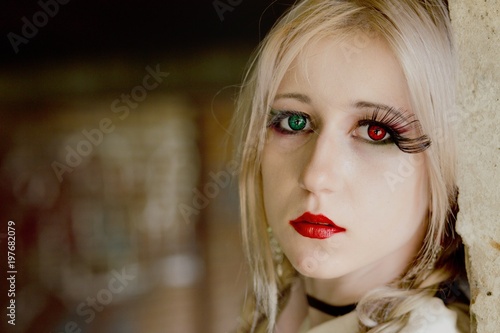 Portrait of a blonde teenage girl with red and green eye