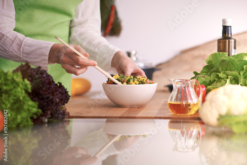 Close Up of human hands cooking vegetable salad in kitchen on the glass table with reflection. Healthy meal  and vegetarian food concept
