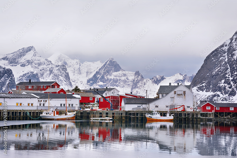 Beautiful winter landscape of harbor with fishing boat and traditional Norwegian rorbus