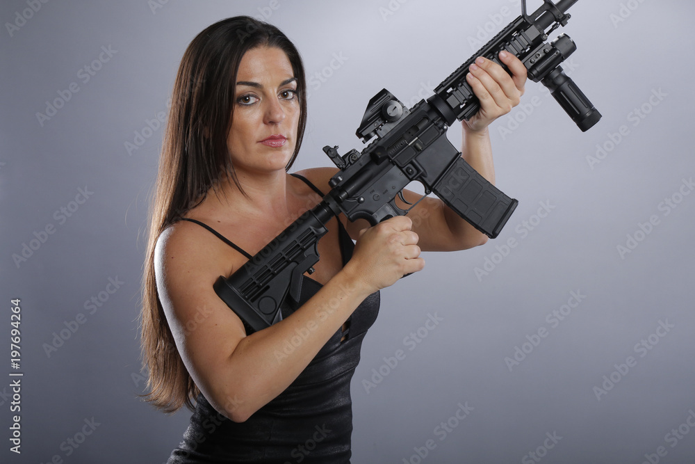 Gorgeous brunette in a little black dress and big gun Gorgeous brunette in a little black dress and big gun