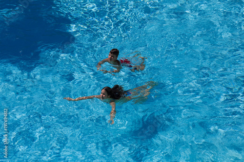 Two kids swim in pool together © Sergiy Bykhunenko