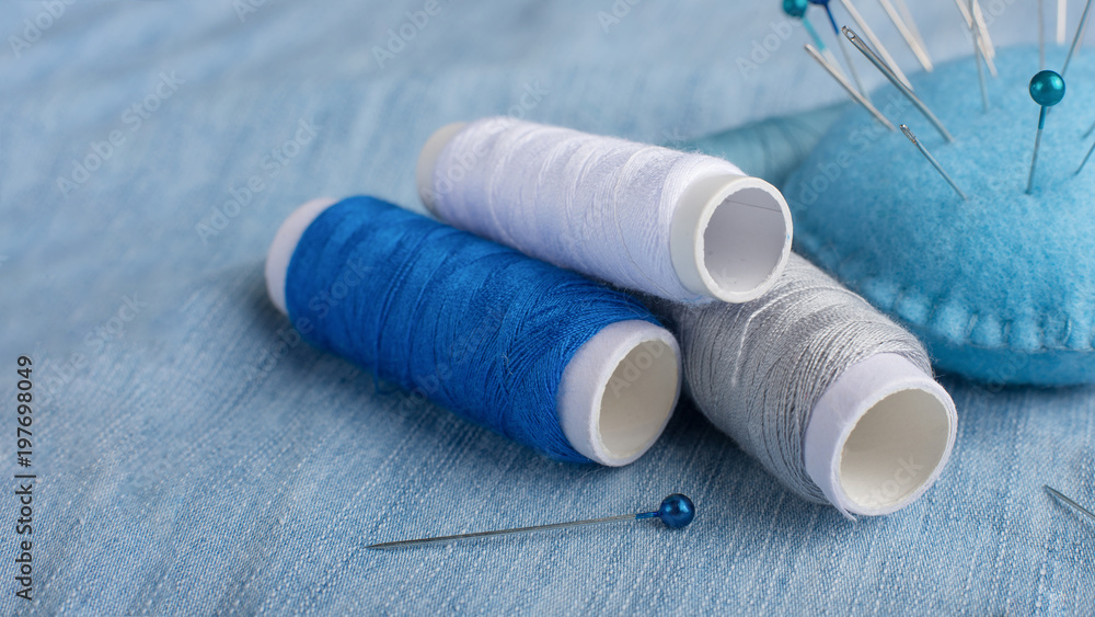 Multicolored thread, needle bed. On the fabric. Macro. With an empty space for text or advertising. Multicolored thread, needle bed. On the fabric. Macro. With an empty space for text or advertising.