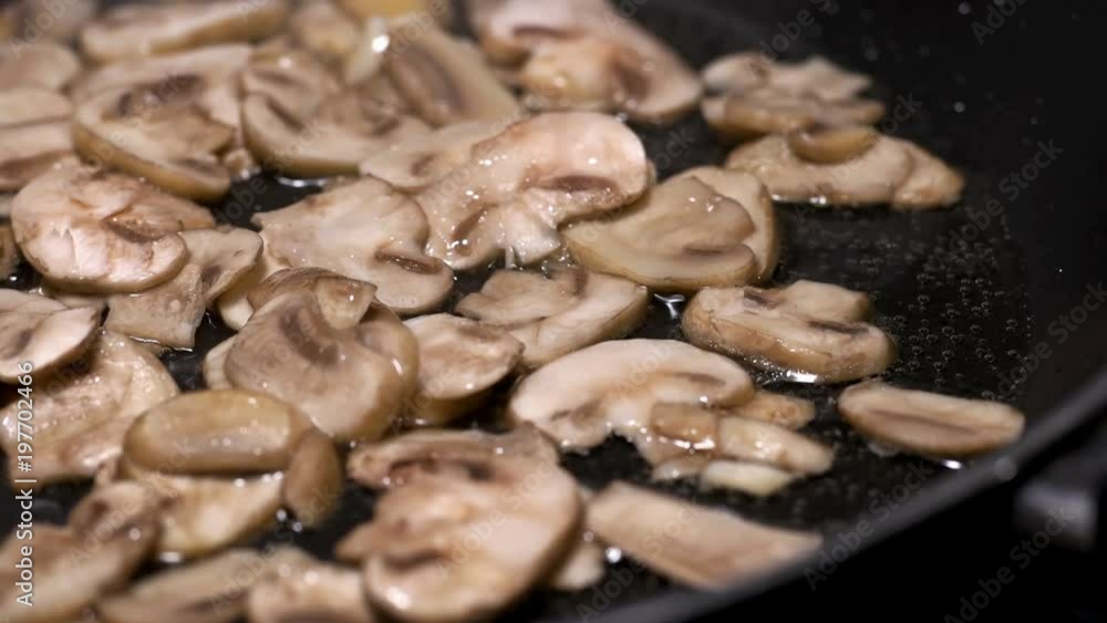 appetizing-looking mushrooms are fried in a pan, close-up appetizing-looking mushrooms are fried in a pan, close-up